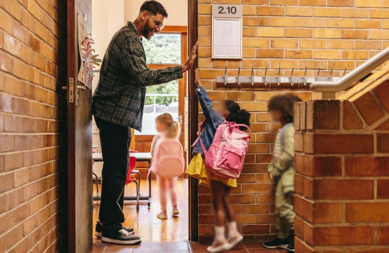 Teacher welcoming student to classroom